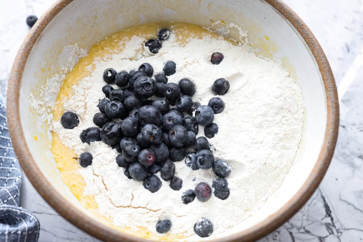 This 5 Ingredient Blueberry Bread is the little shortcut loaf you’ll make once and then suddenly need every weekend. It’s soft, sweet, full of juicy blueberries, and comes together with only five simple ingredients. Butter mixture with flour and blueberries on top.