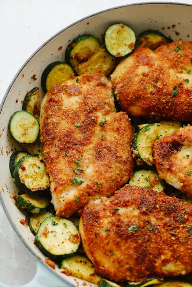 My family and I cannot get enough of this versatile summer vegetable! Whether you use it for a side dish or the entrée, its tender texture and ability to absorb flavor is unmatched. Take advantage of zucchini being in season and try out some of my other favorite zucchini recipes! Cooked parmesan garlic chicken with zucchini in a white bowl.
