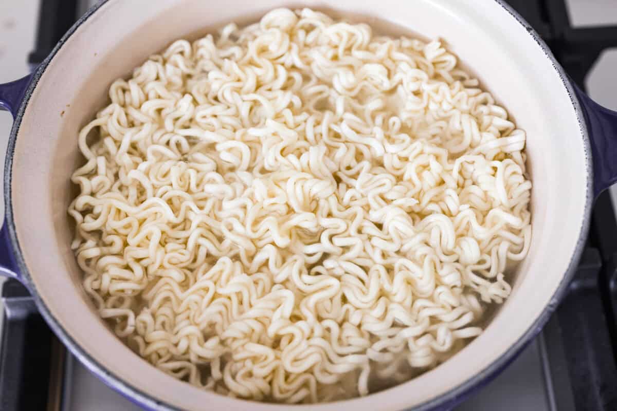 These dragon noodles are the ultimate weeknight dinner when you’re craving big flavor fast. Tender noodles, spicy-sweet sauce, and savory pork come together for a dish that’s fast, fiery, and seriously addictive. Ramen noodles cooking in a pot.