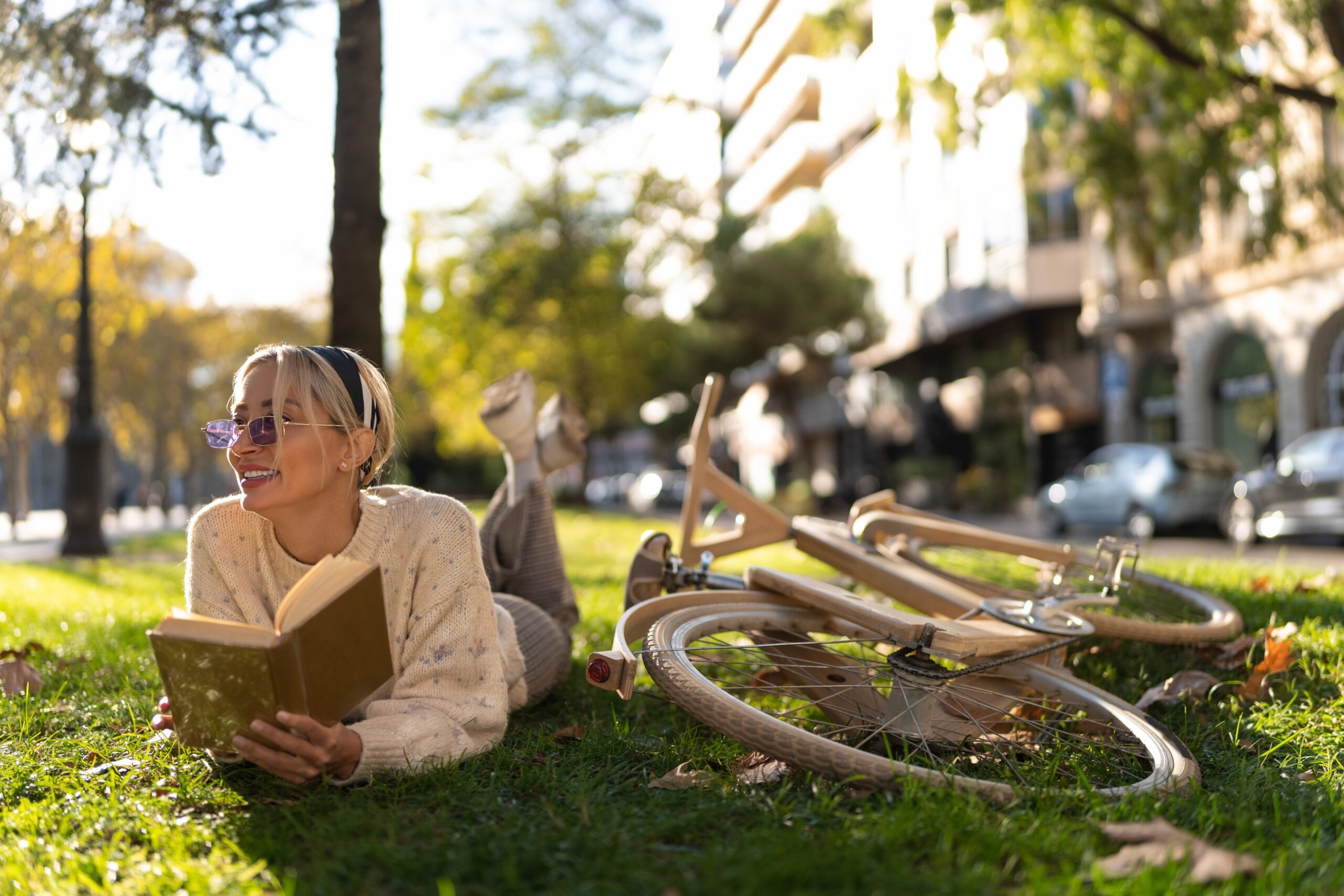 woman reading summer books with her bike