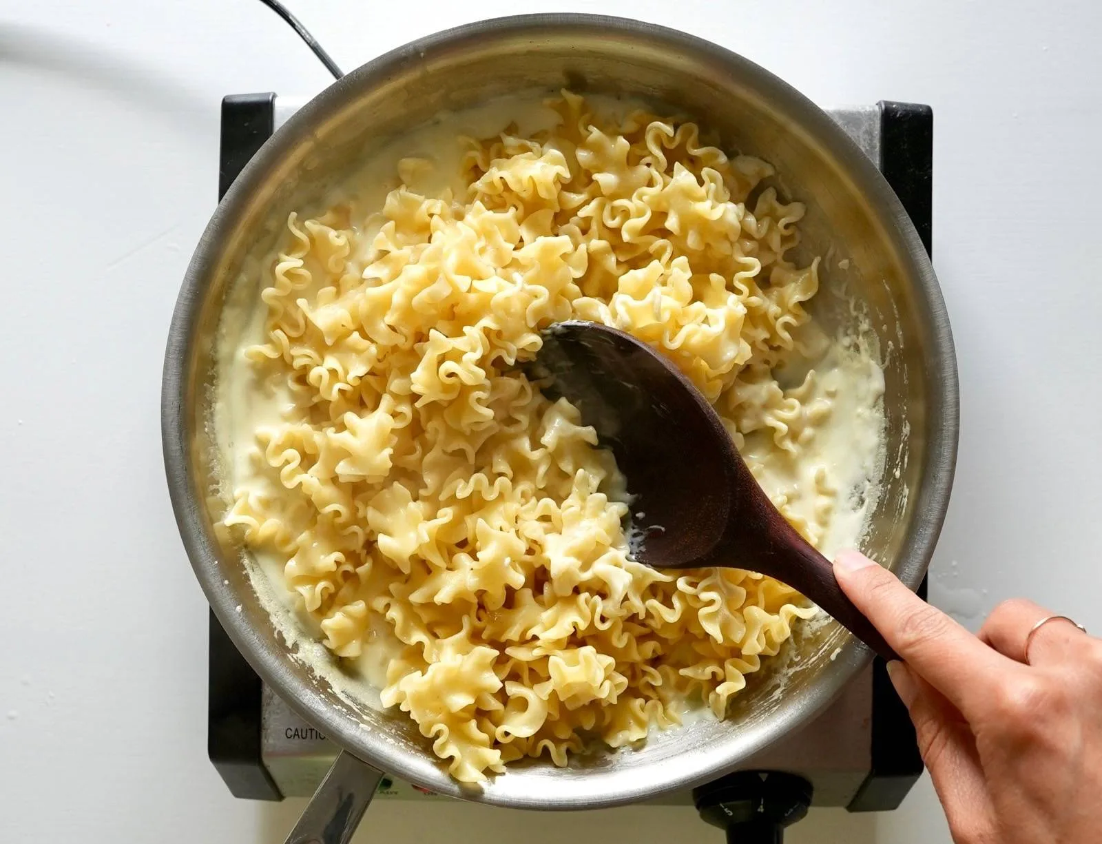 Adding pasta to lemon sauce.