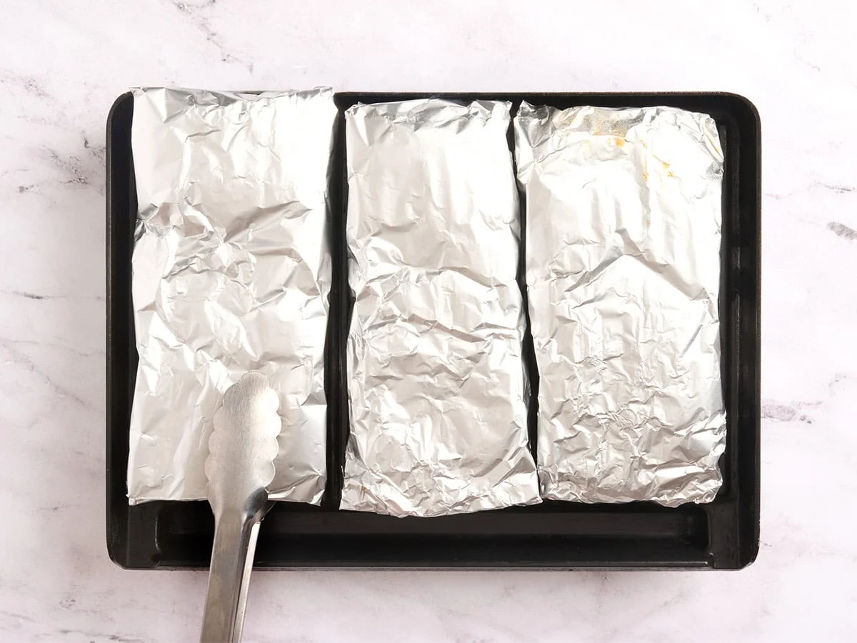 BBQ chicken packets on a grill.