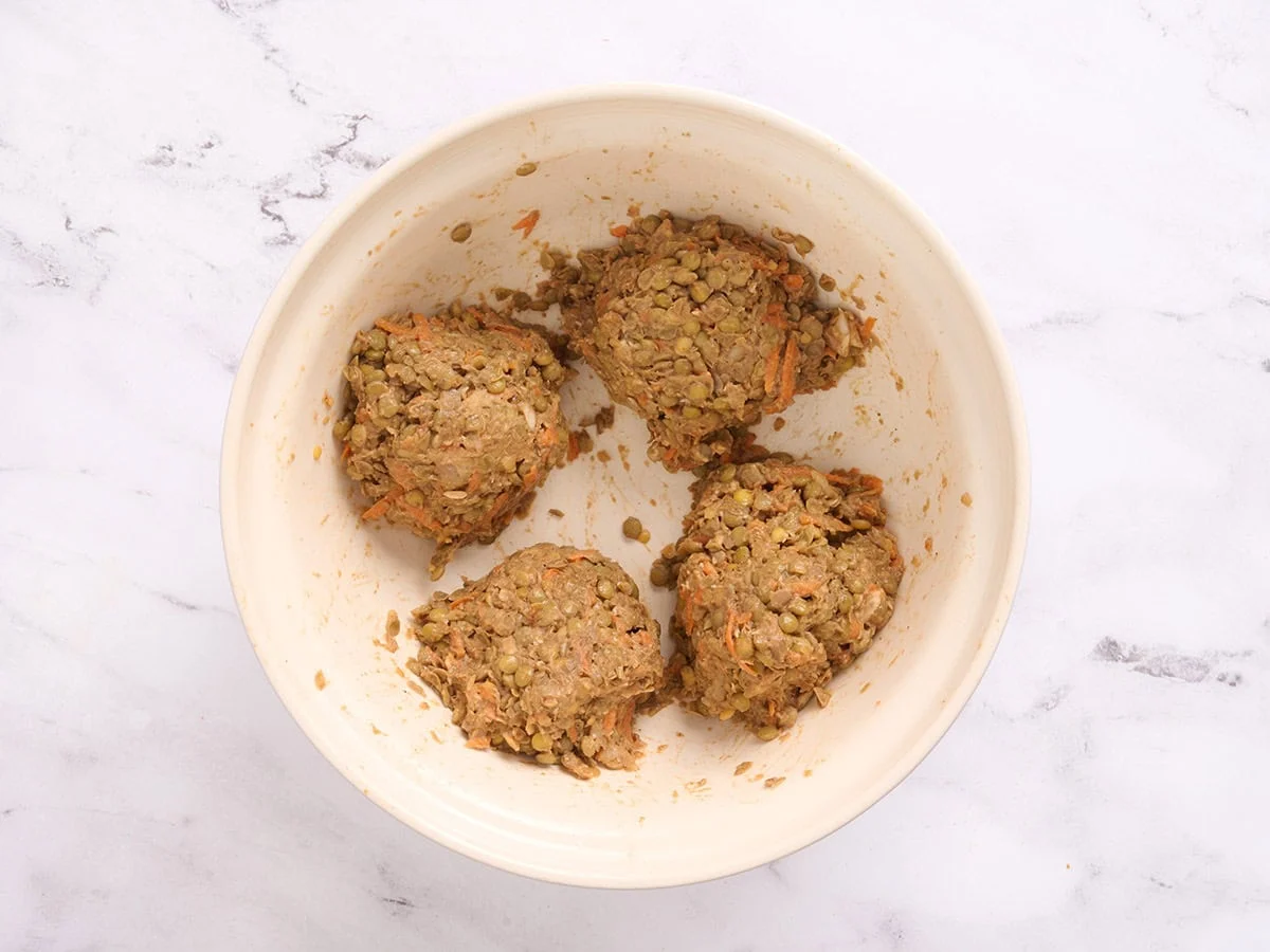 Lentil burger mixture formed into four balls in a bowl.