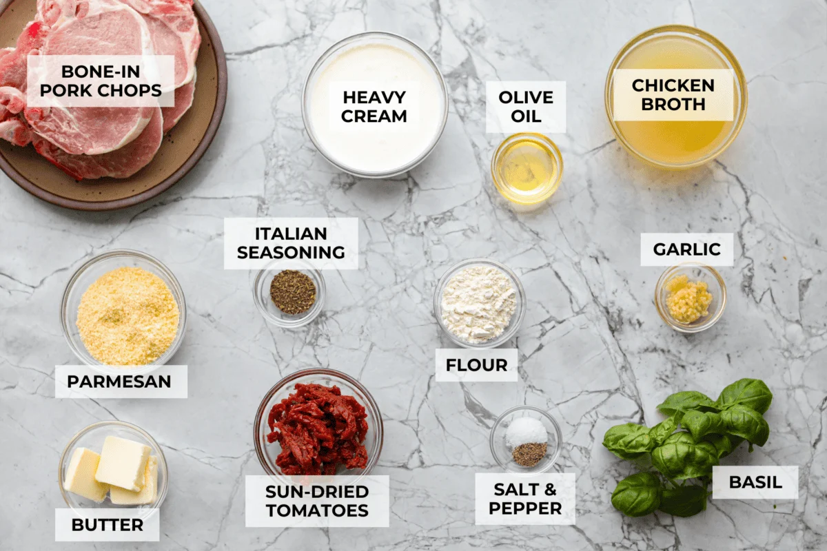Marry Me pork chops are the kind of dinner that earns its name! Tender pork chops are simmered in a rich, creamy Parmesan sauce with garlic, Italian herbs, and sweet, tangy sun-dried tomatoes. One bite and you’ll get why they’re worth proposing over. Overhead shot of labeled ingredients.
