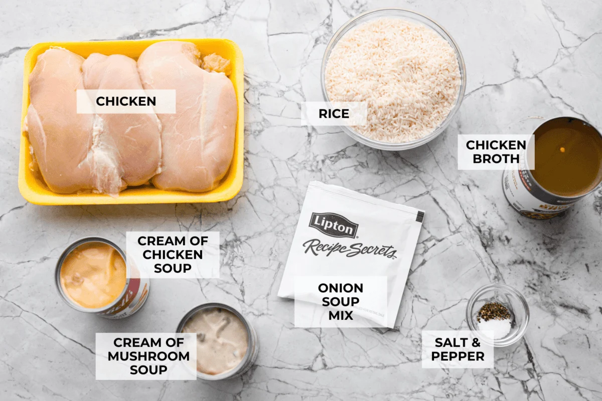 No peek chicken and rice casserole is the ultimate easy comfort food. Tender chicken and creamy, flavorful rice bake together in one dish. Just cover it tightly, pop it in the oven, and whatever you do, don’t peek! Overhead shot of labeled chicken and rice casserole ingredients.