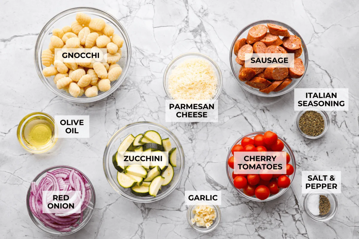 This sheet pan gnocchi is about as easy as dinner gets! Everything goes onto one pan with olive oil and Italian seasoning, then roasts until the gnocchi is crispy and the veggies are tender. Finish it with Parmesan and dig in! Overhead shot of labeled ingredients.
