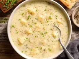 Overhead view of a bowl of classic potato soup with a spoon.
