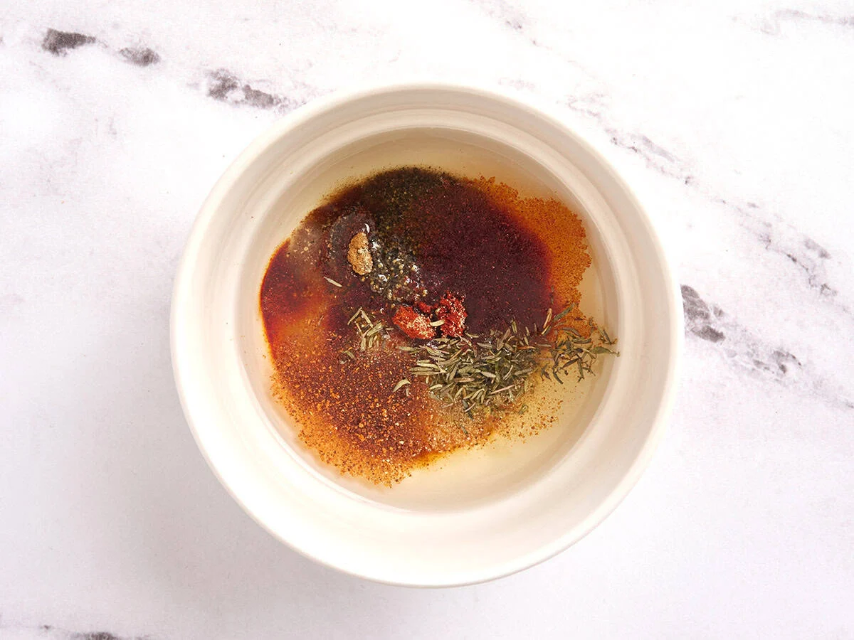 Seasonings added to a bowl of oil.