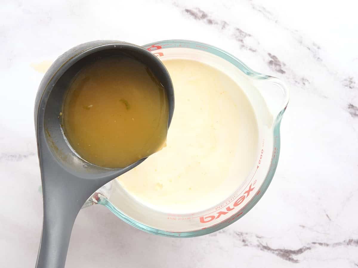 Broth being added to half and half to temper the dairy.