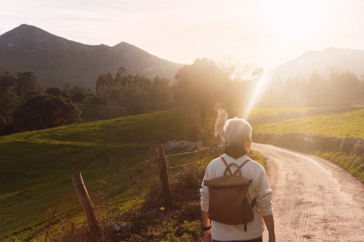 Older woman from behind doing hiking.