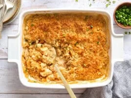 Overhead view of a million dollar chicken casserole in a casserole dish with a spoon.