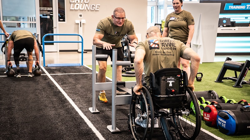 Robert Irvine encourages a veteran during a Robert Irvine Foundation fitness event.