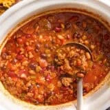 Overhead view of crockpot chili with a ladle.
