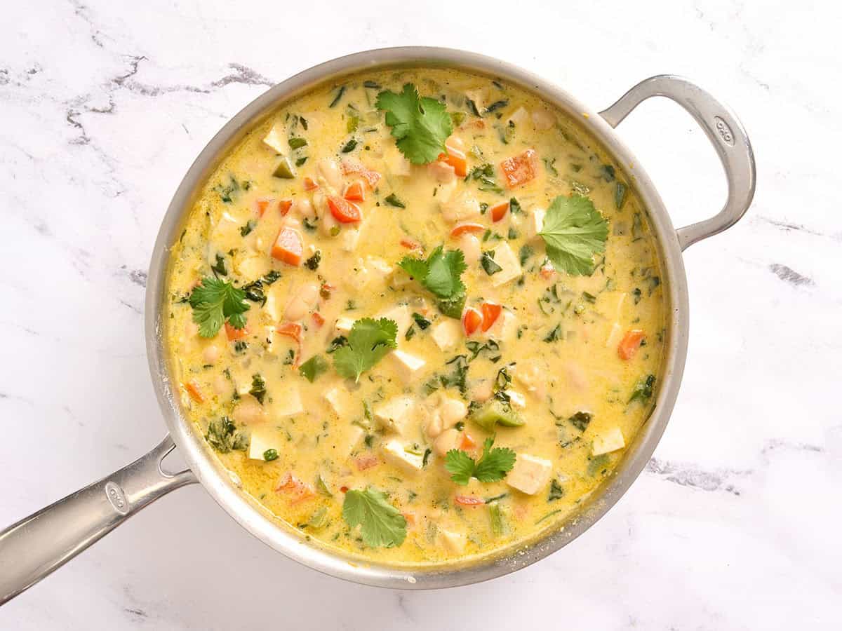 Overhead view of a skillet of coconut curry beans and greens.