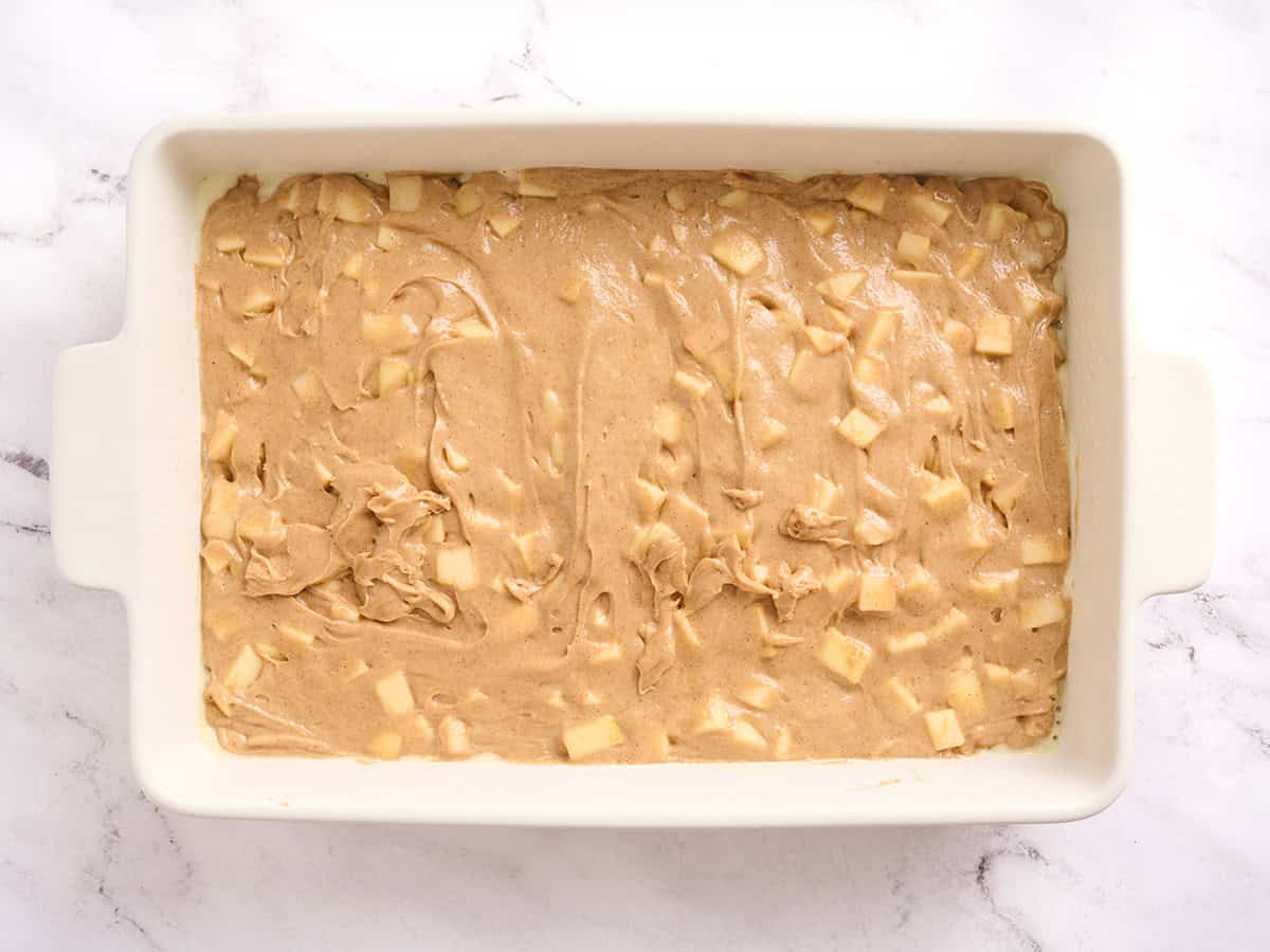 The batter for an apple spice cake in a baking dish.