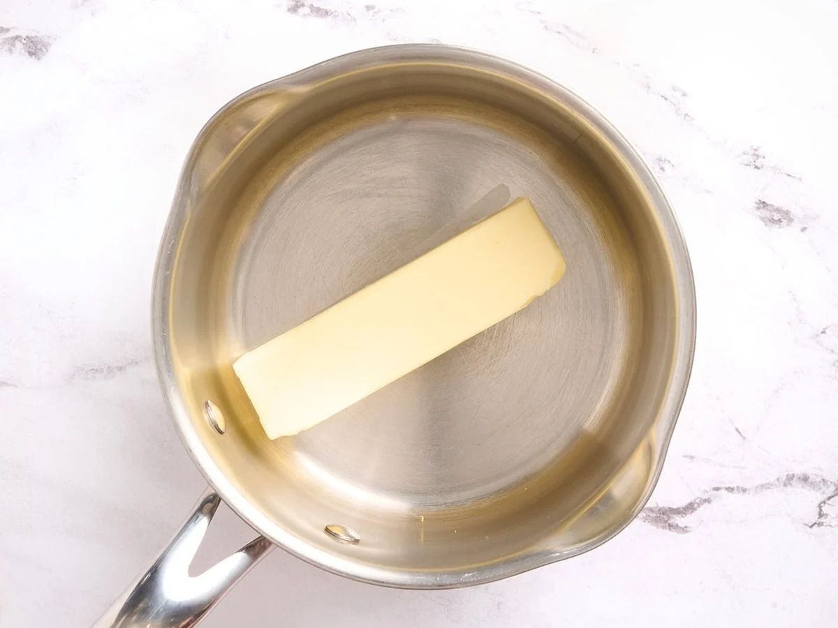A stick of butter in a sauce pan.