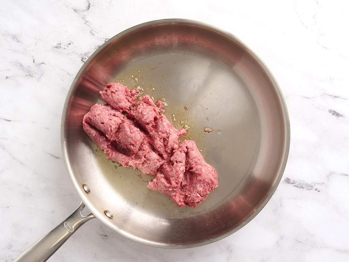 Ground beef being browned in a skillet.