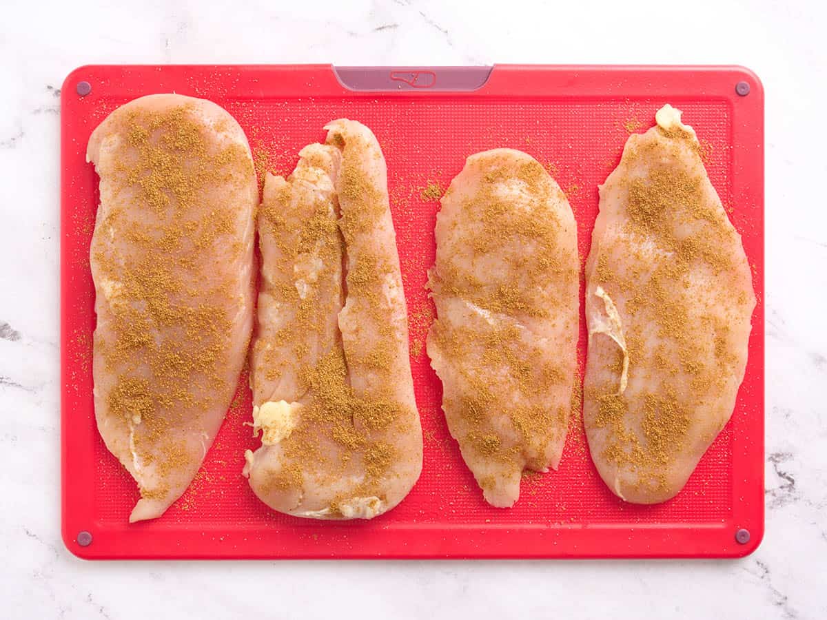Fileted chicken breasts seasoned with jerk seasoning.