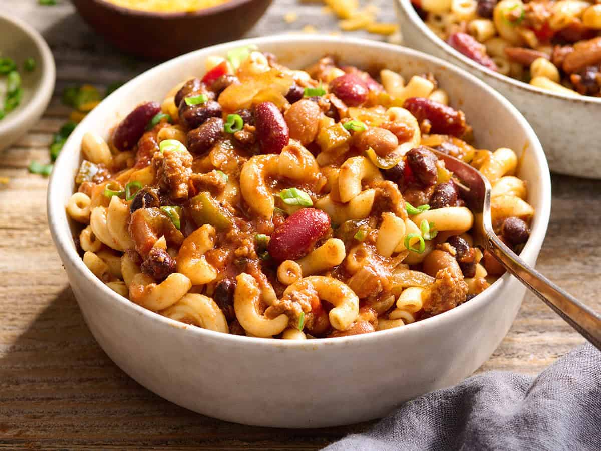 Side view of a bowl of macaroni topped with slow cooker chili.