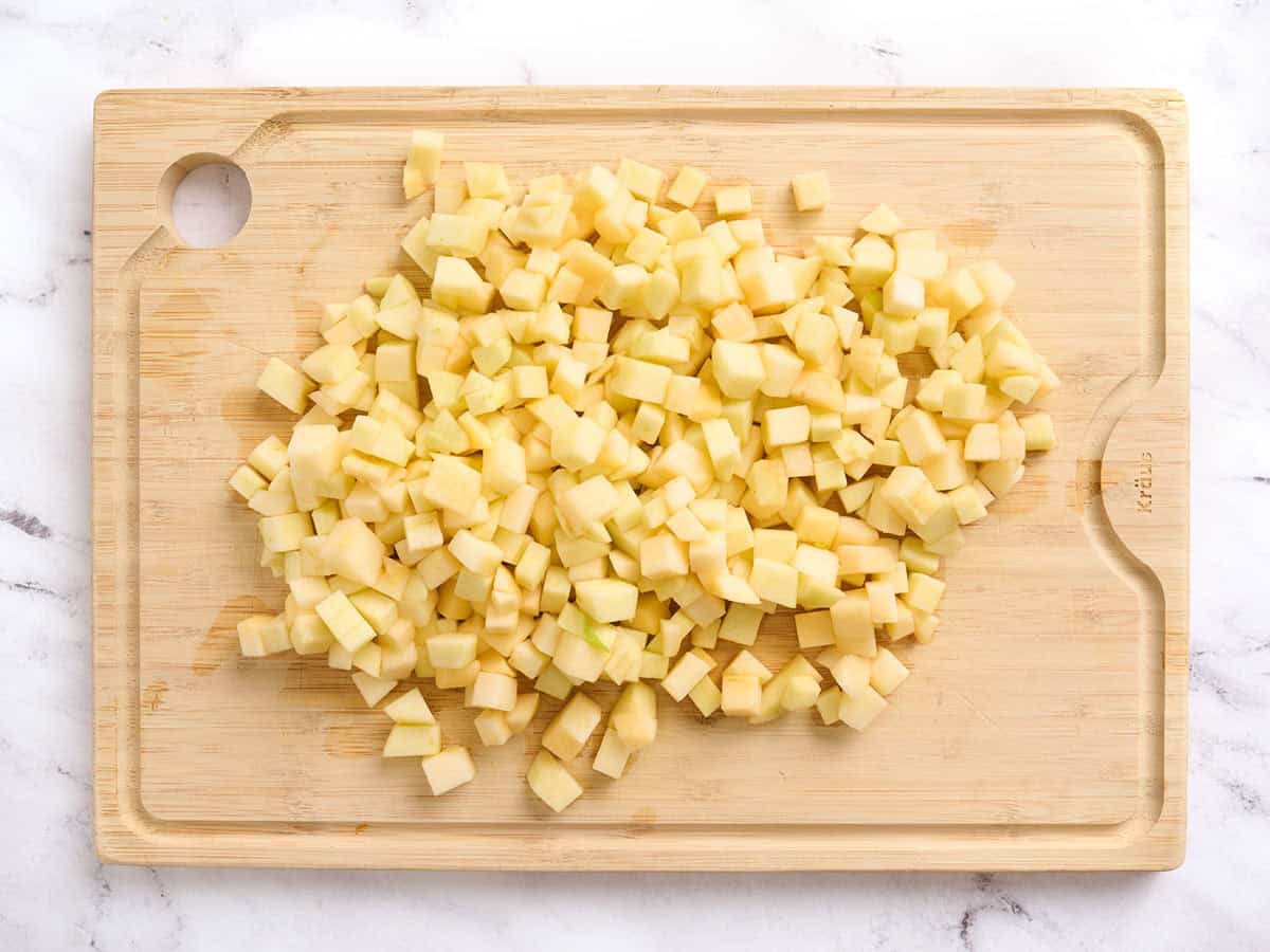 Diced apples on a wooden cutting board.