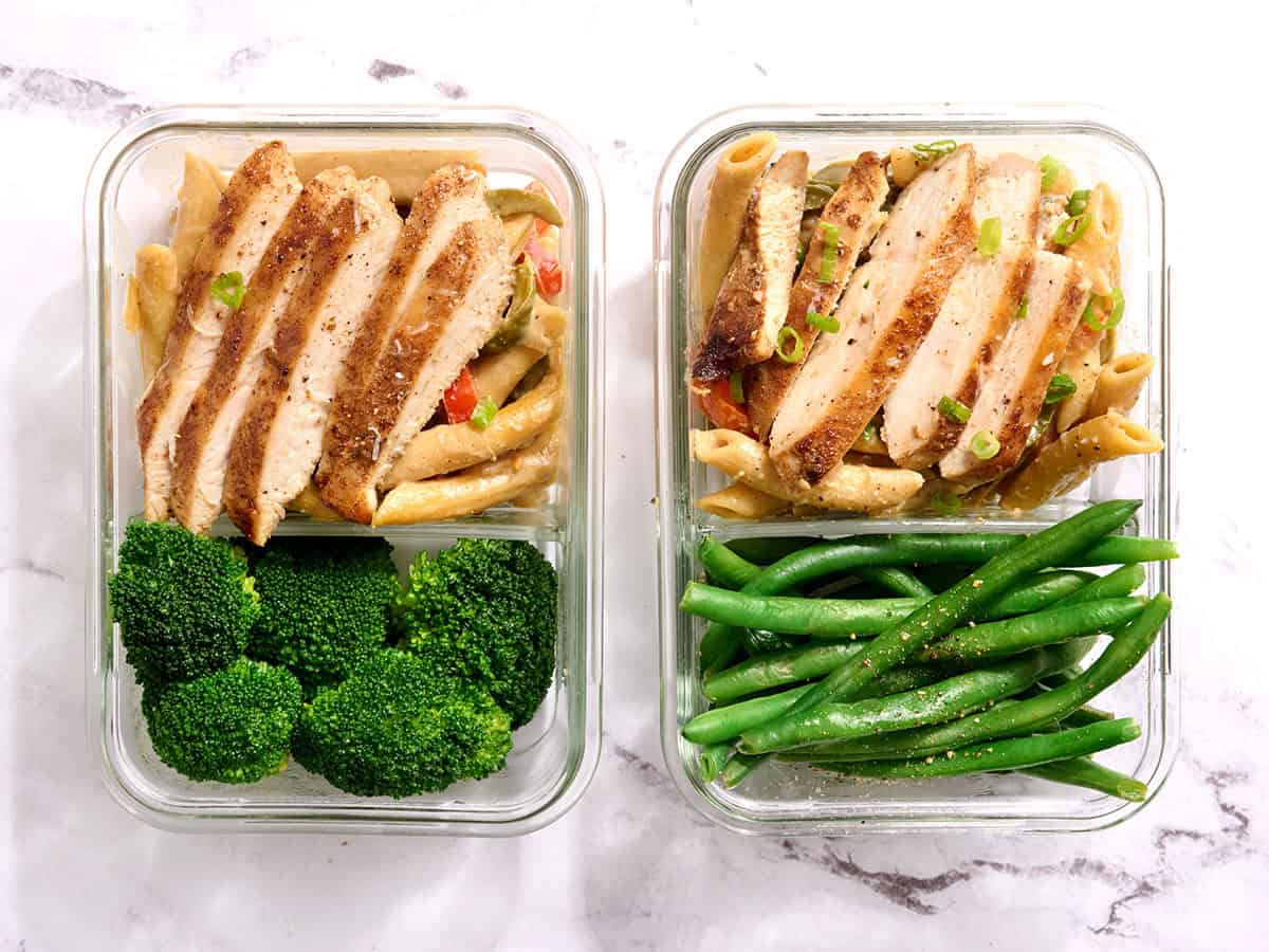 Rasta pasta in meal prep containers, one with broccoli and one with green beans.