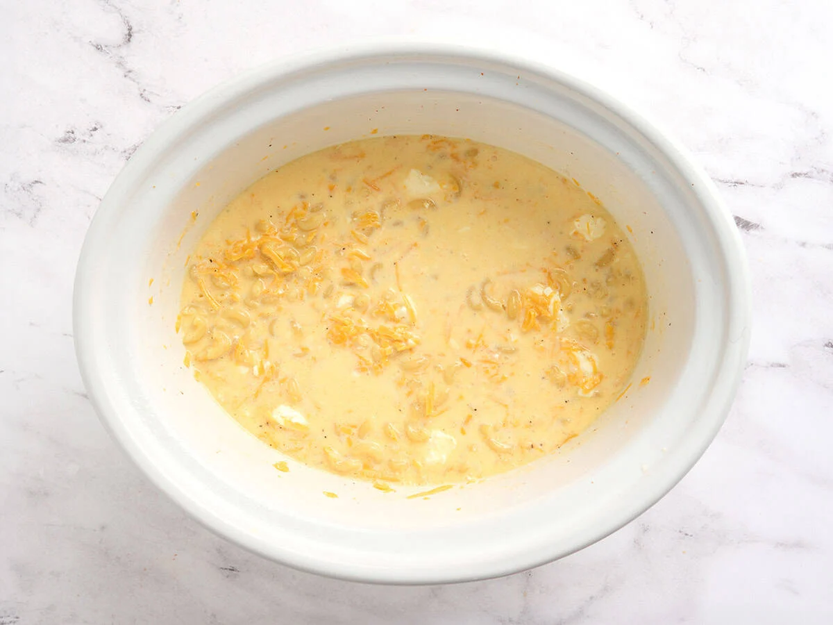 Everything added to a slow cooker to make mac and cheese.