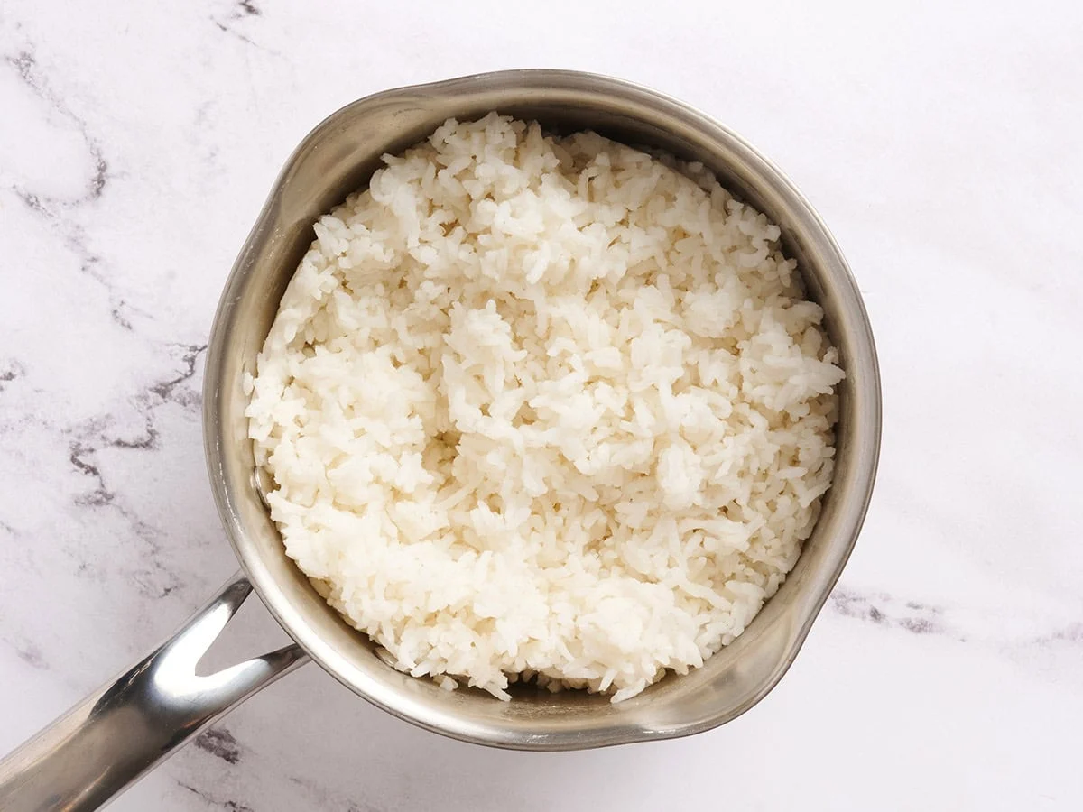 Cooked white rice in a sauce pan.