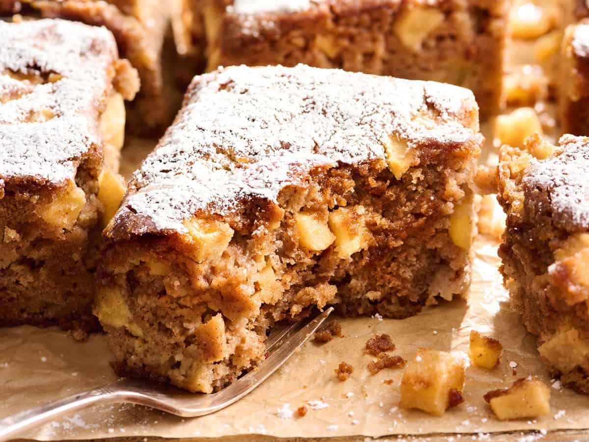 Side view of an apple spice cake with a bite missing.