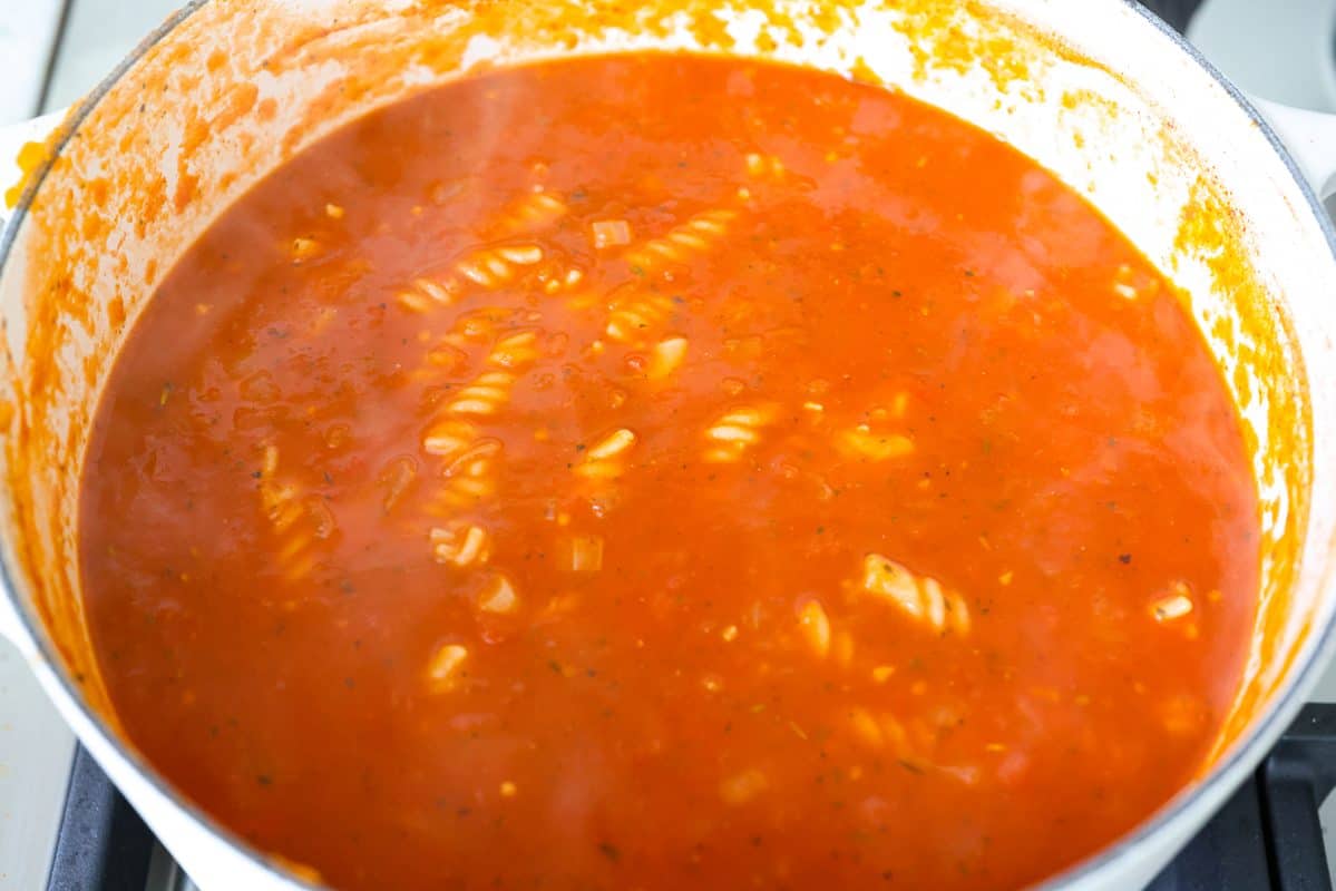 Craving chicken parm? Grab a spoon! This chicken parmesan soup is loaded with tender chicken, pasta, and a rich, creamy tomato broth. Finish with crispy, buttery breadcrumbs for a delicious twist on the Italian classic! Pasta added to the pot to cook.