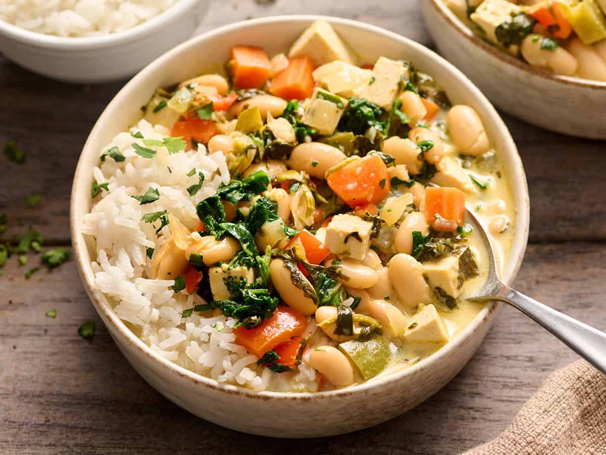 A bowl of coconut curry beans and greens with rice.
