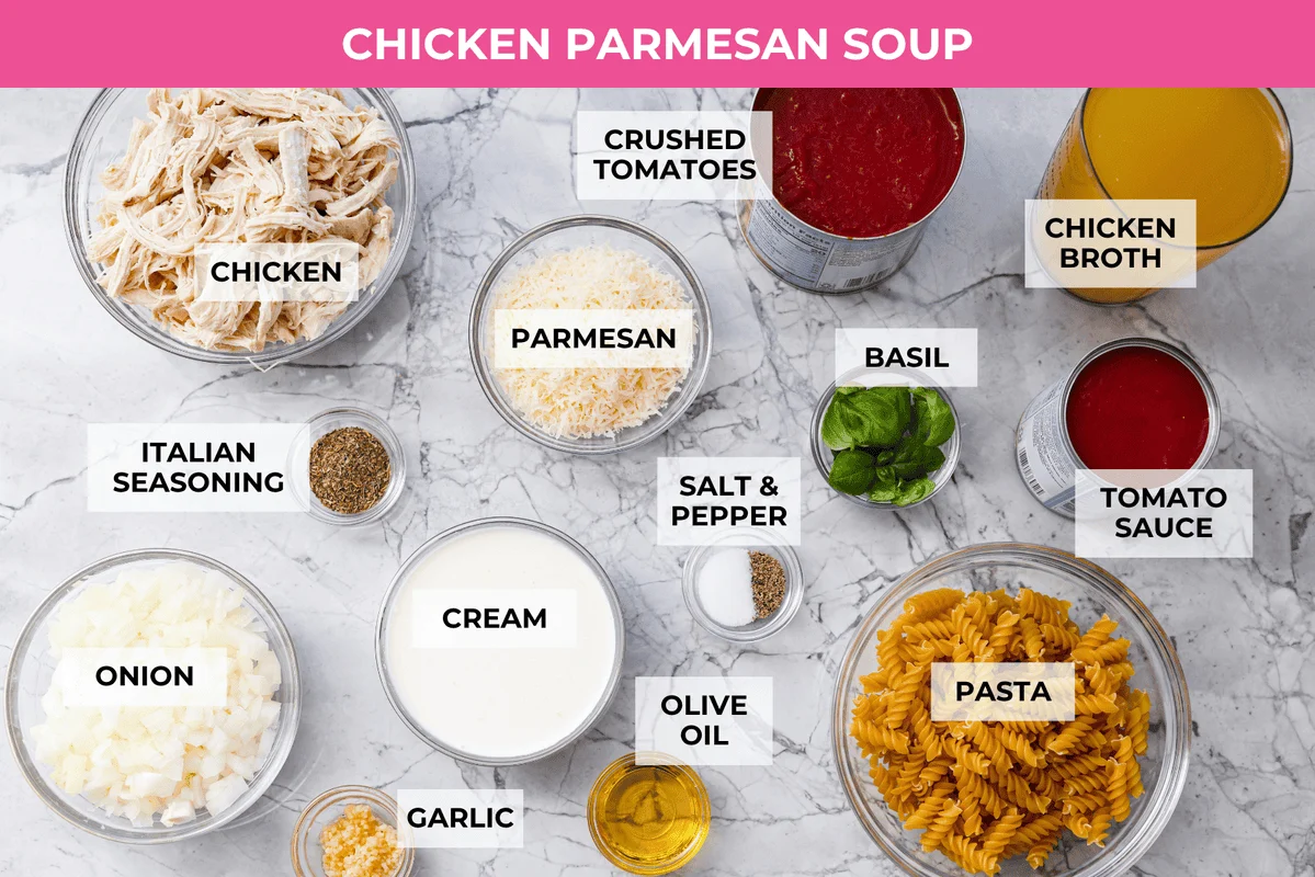 Craving chicken parm? Grab a spoon! This chicken parmesan soup is loaded with tender chicken, pasta, and a rich, creamy tomato broth. Finish with crispy, buttery breadcrumbs for a delicious twist on the Italian classic! Overhead shot of labeled chicken parmesan soup ingredients.