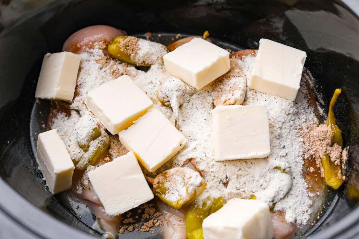 Seasoning packets and butter added to the top of the chicken. 