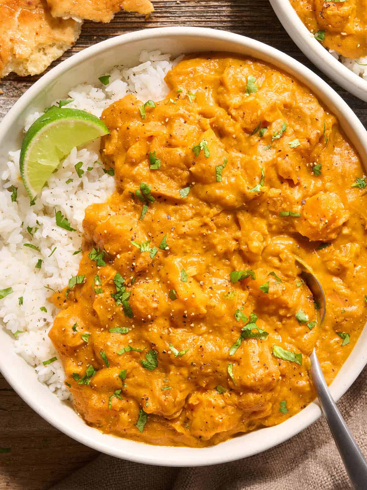 Overhead view of a bowl of pumpkin curry with white rice.