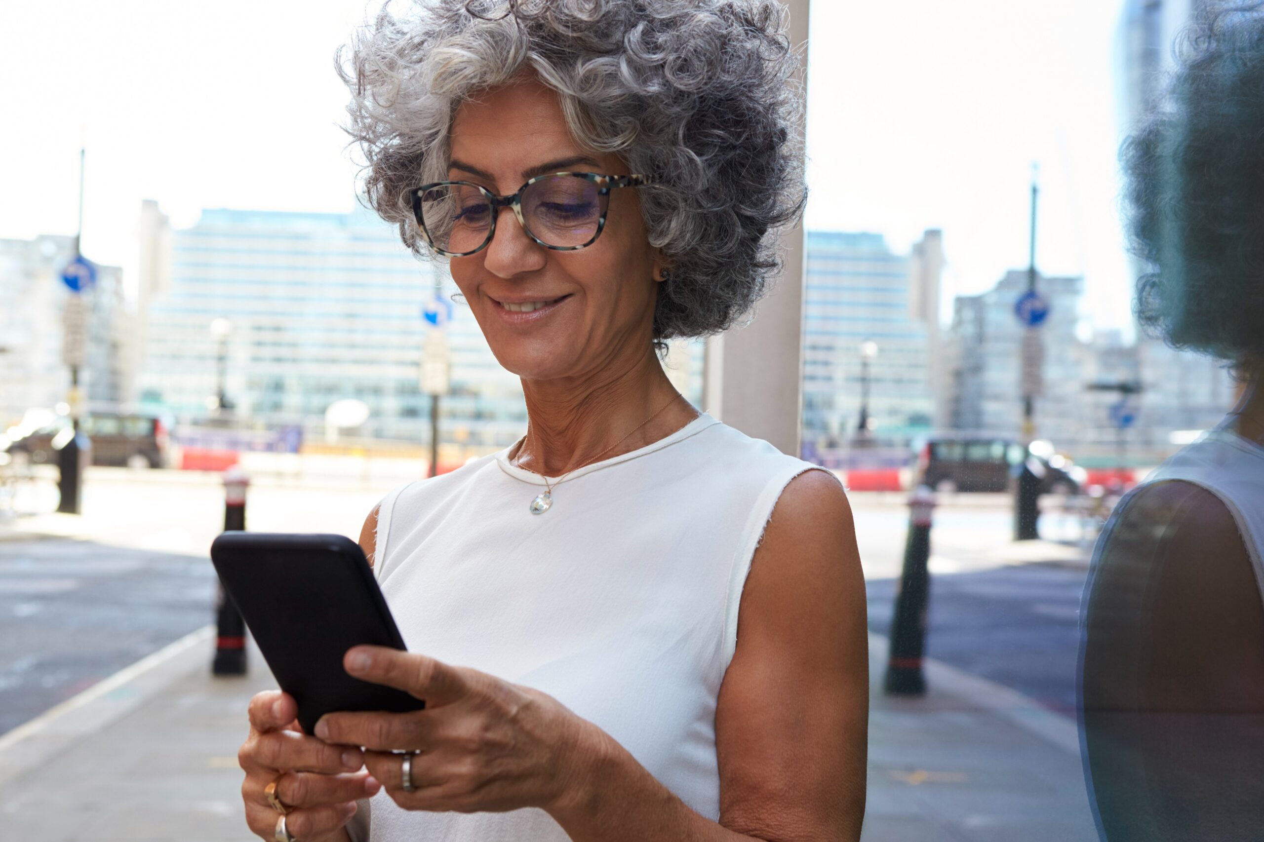 older woman using phone solo travel safety travel